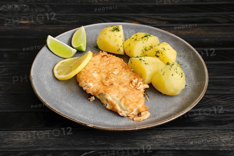 Plate with fried cod steak in cheese breading fried with boiled potato