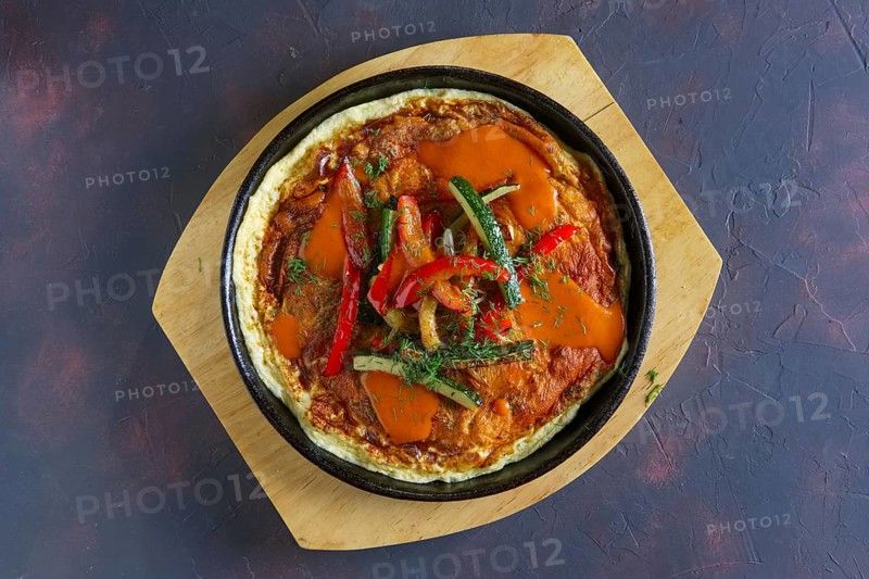 Top view of omelette with paprika and zucchini. Rural breakfast