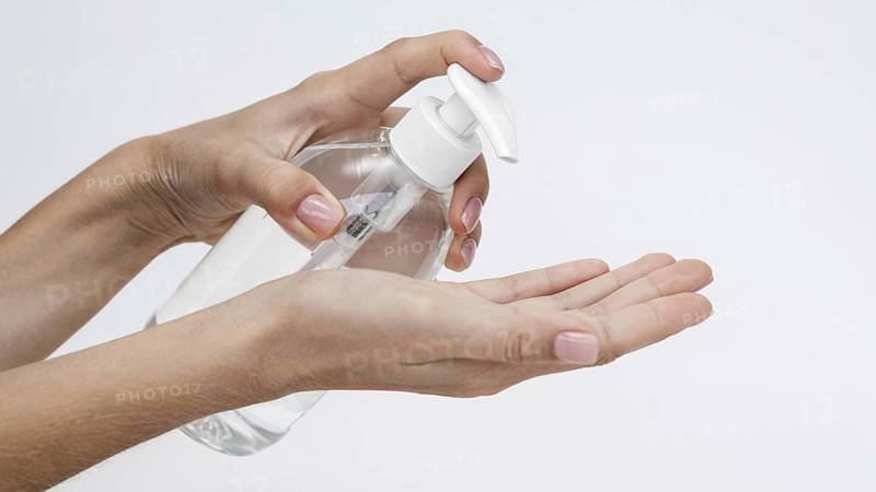Person pouring liquid soap from bottle with copy space