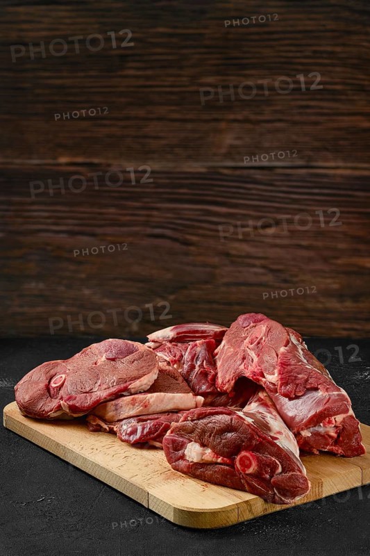 Assortment of raw fresh lamb meat on wooden tray