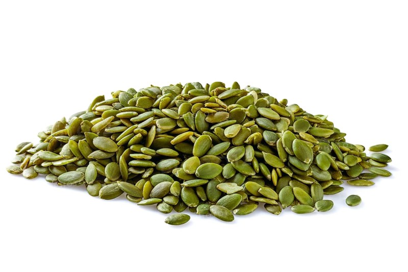 Heap of peeled pumpkin seeds isolated on white
