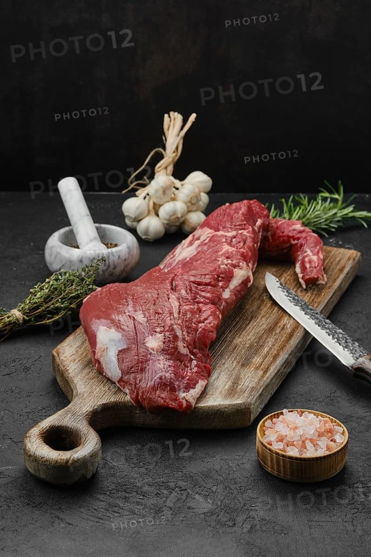 Raw beef tri-tip loin on wooden cutting board