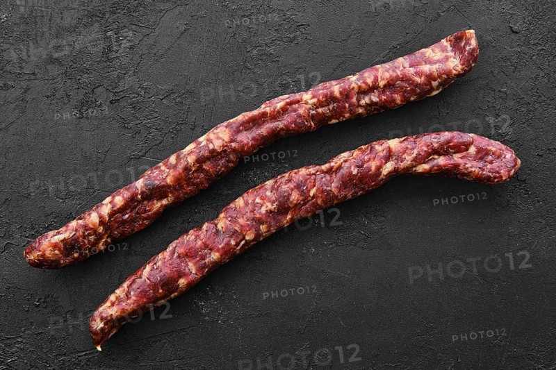 Top view of sun-dried pork sausage on black background