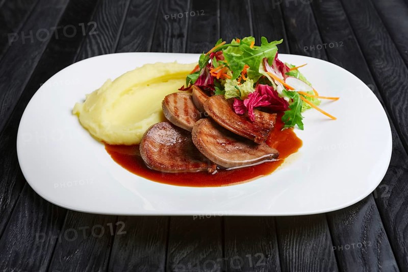 Beef tongue with mashed potato and salad with lingonberry sauce