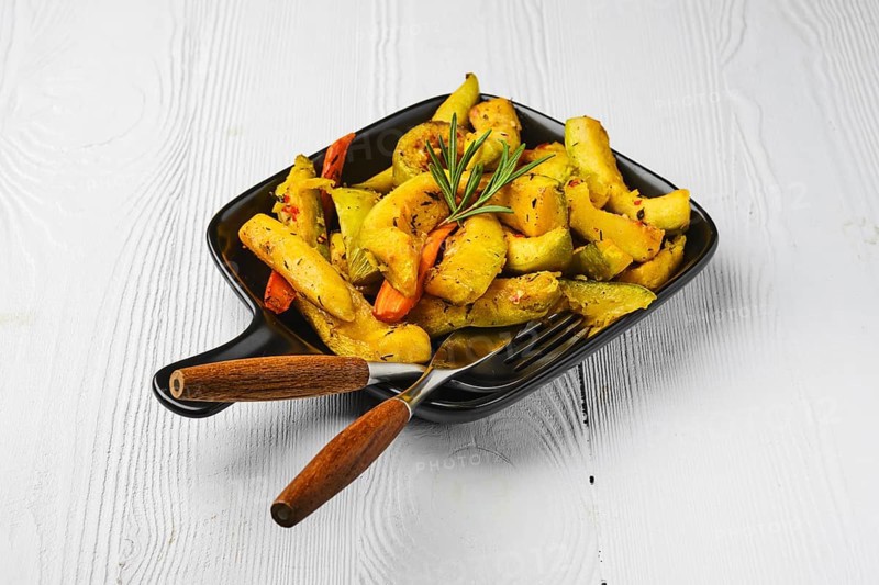 Spicy pumpkin and carrot baked in oven on ceramic plate