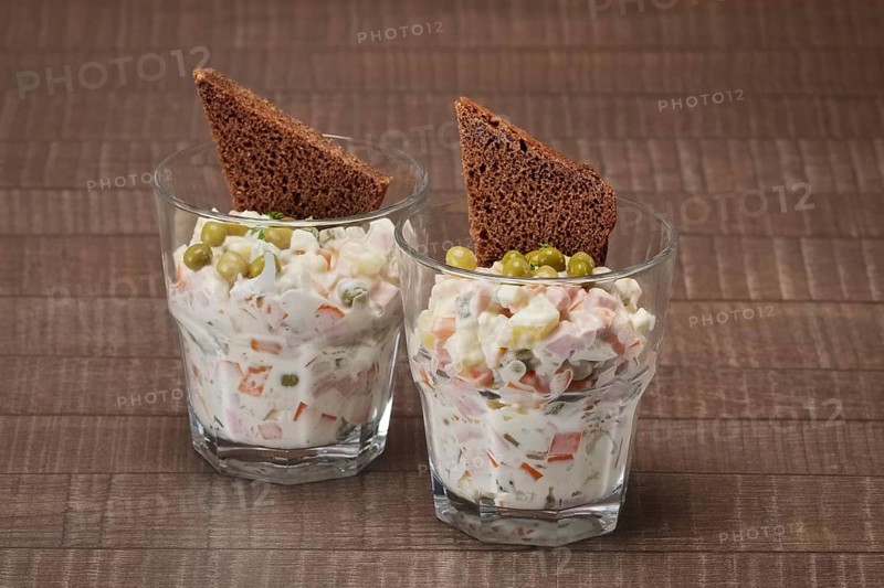 Russian traditional salad olivier with pea in glass