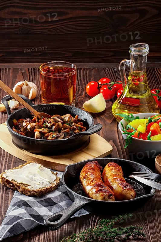 Fried mushrooms and egg in cast iron pan. Ingredients for rustic breakfast on wooden table