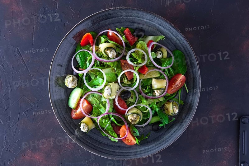 Fresh salad with zucchini stuffed with feta cheese with tomato