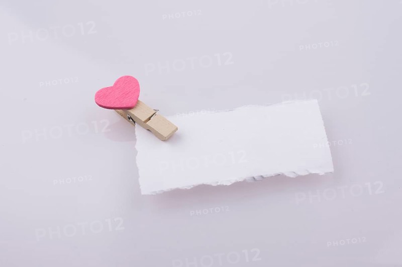 Pink hearted clip on a white note paper