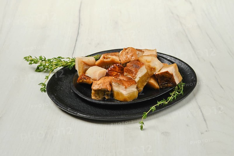 Frozen fresh boletus cut on pieces on black stone plate