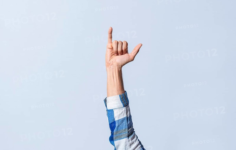 Hand gesturing the letter Y in sign language on an isolated background. Man's hand gesturing the letter Y of the alphabet isolated. Letter Y of the alphabet in sign language