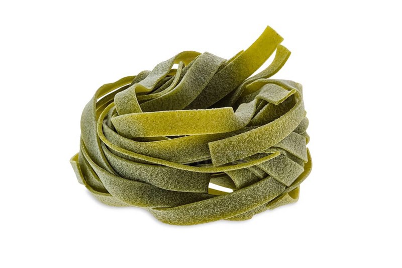 Nest noodles isolated on white background. Italian tagliatelle with spinach
