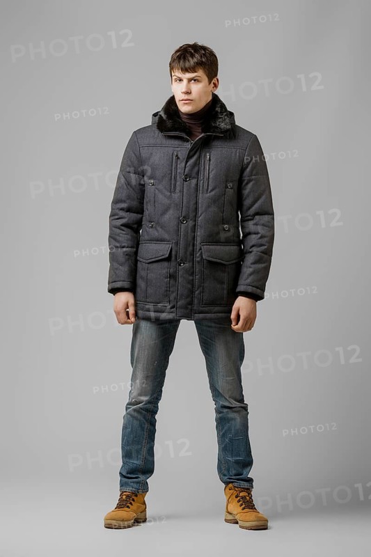 Full length portrait of handsome man in warm winter coat posing in studio