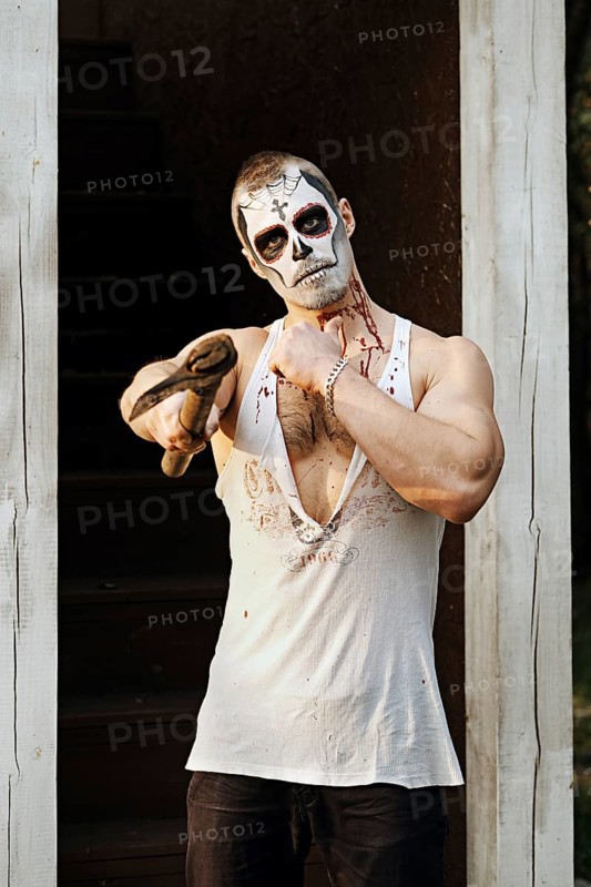 Male daemon with axe near firewood placing. Face painting art