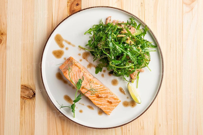 Steamed salmon with arugula and shrimps garnish