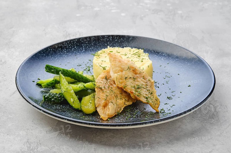 Fried zander fillet in breading with mashed potatoe and pickled cucumber