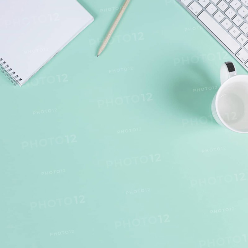 Close up blank notepad pencil cup keyboard turquoise background with space text