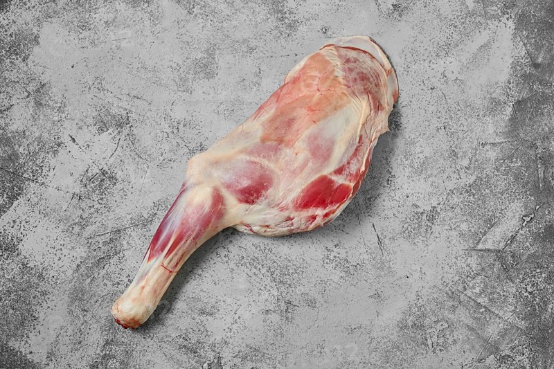 Raw lamb shoulder chump on on shabby grey background