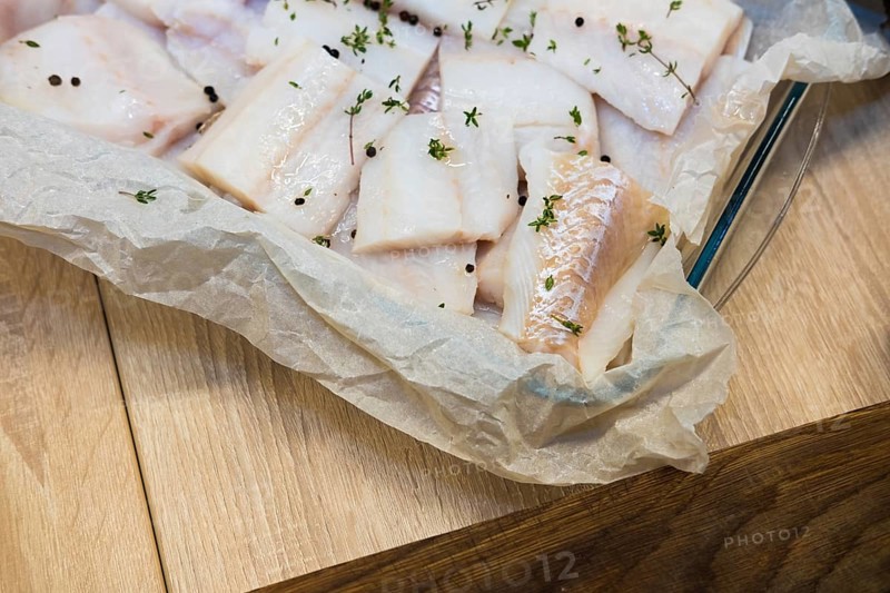 Fresh white fish fillet on cooking paper