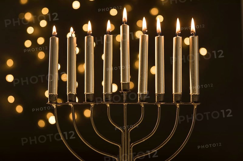 Menorah with candles near abstract garland lights