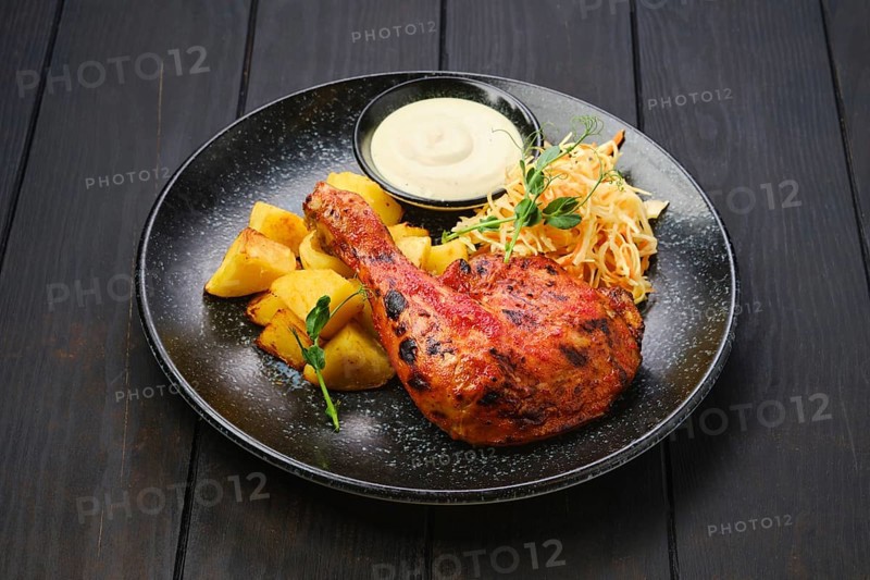 Whole roasted chicken thigh with potato wedges and pickled cabbage