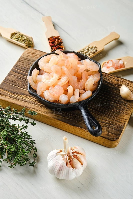 Frozen peeled shrimps in frying pan