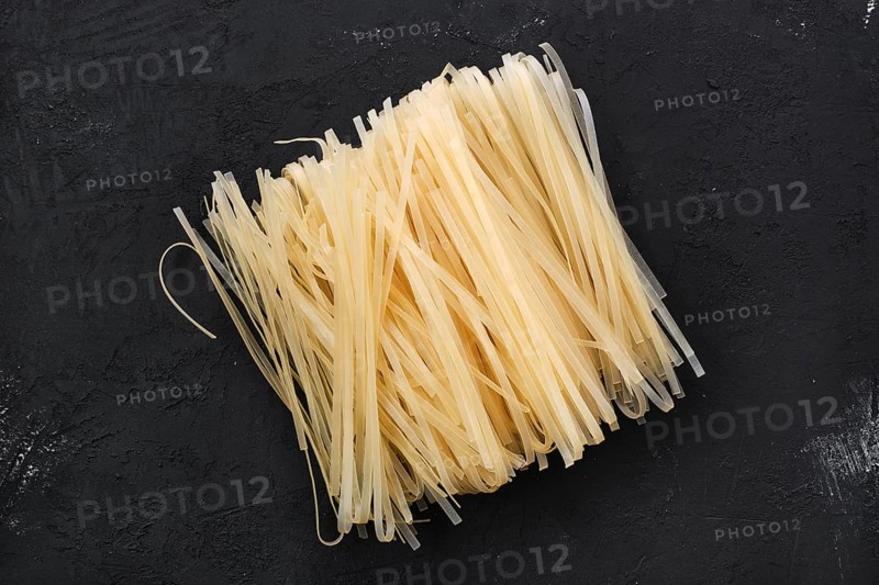 Dry rice stick noodles on black concrete background