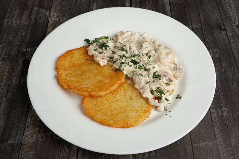 Top view of plate with draniki and mushroom cream sauce