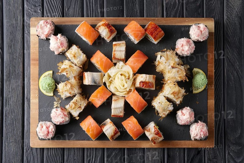 Big set of rolls served on stone plate. Layout for menu