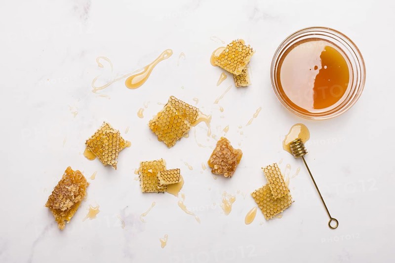 Glass jar full honey with honey spoon