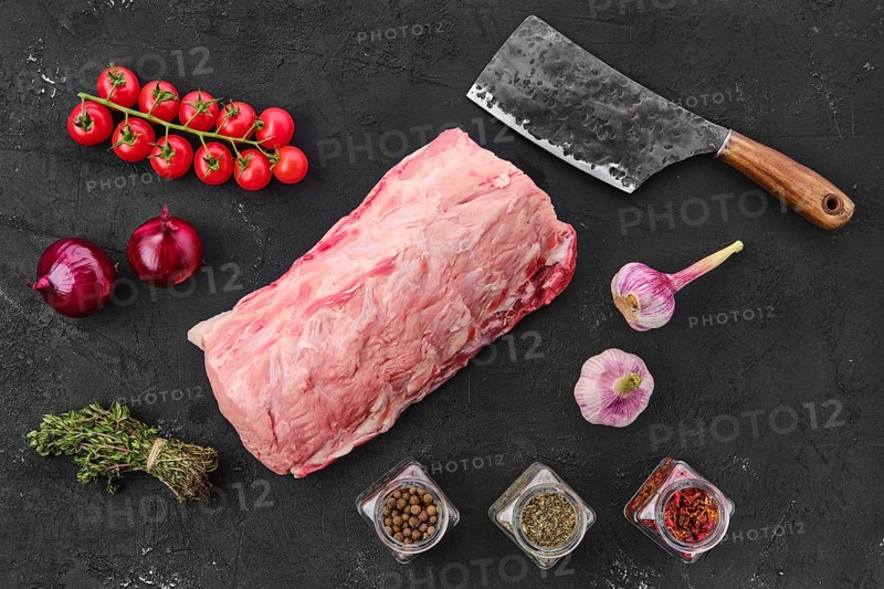Raw fresh pork collar joint meat on black background with spice