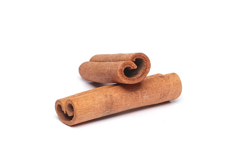 Two cinnamon sticks on white background with shadow