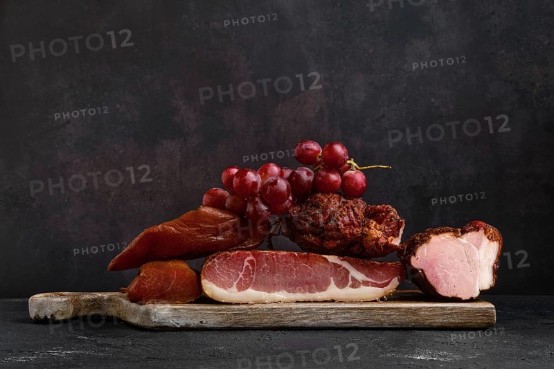Wooden cutting board with assortment of pork ham