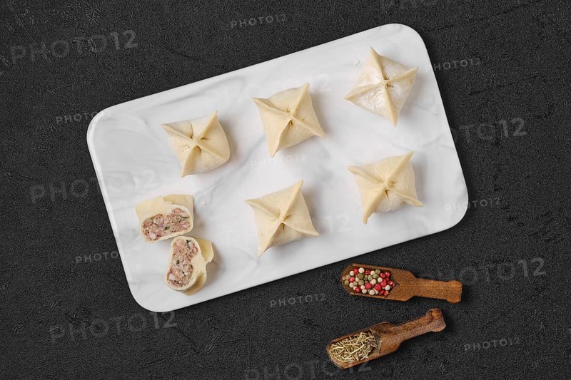 Top view of homemade spicy beef dumplings on marble serving plate