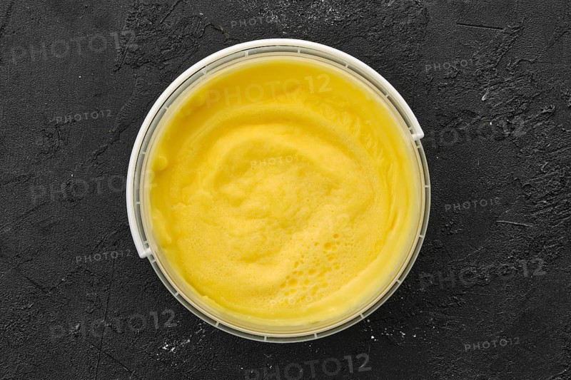Top view of homemade cream cheese in plastic bowl
