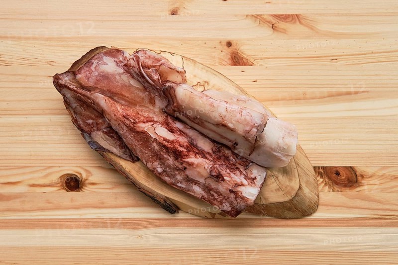 Frozen fresh octopus or squids raw on wooden board