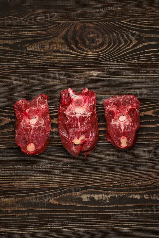 Overhead view of raw fresh deer neck over dark wooden background