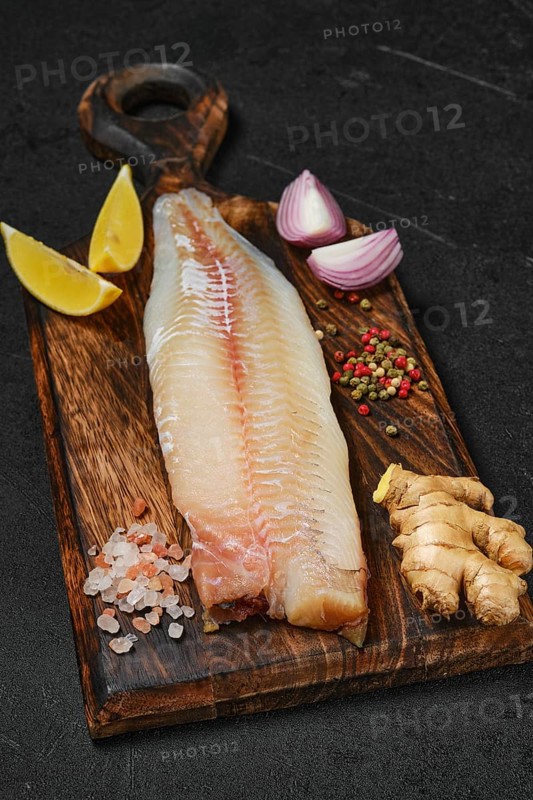 Freshly frozen zander fillet on wooden cutting board