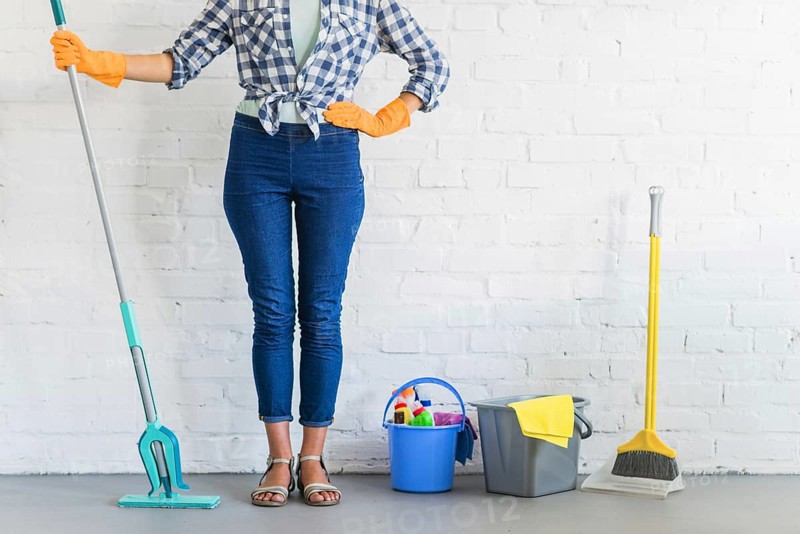 Woman standing front brick wall with cleaning equipments. Resolution and high quality beautiful photo