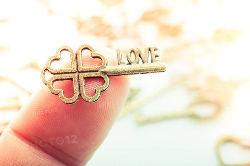 Hand and retro style metal keys on a white background