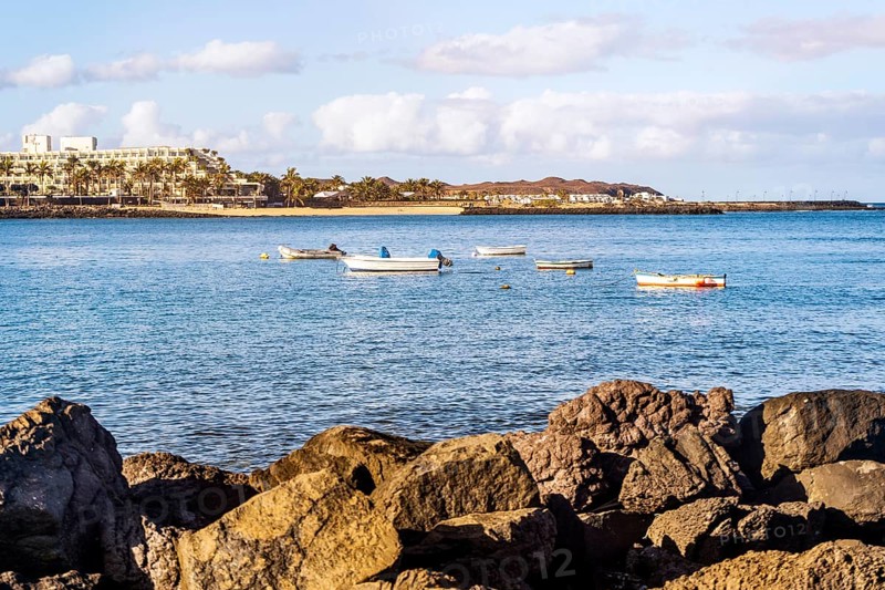 View of the resort town named Costa Teguise with boats on the foreground
