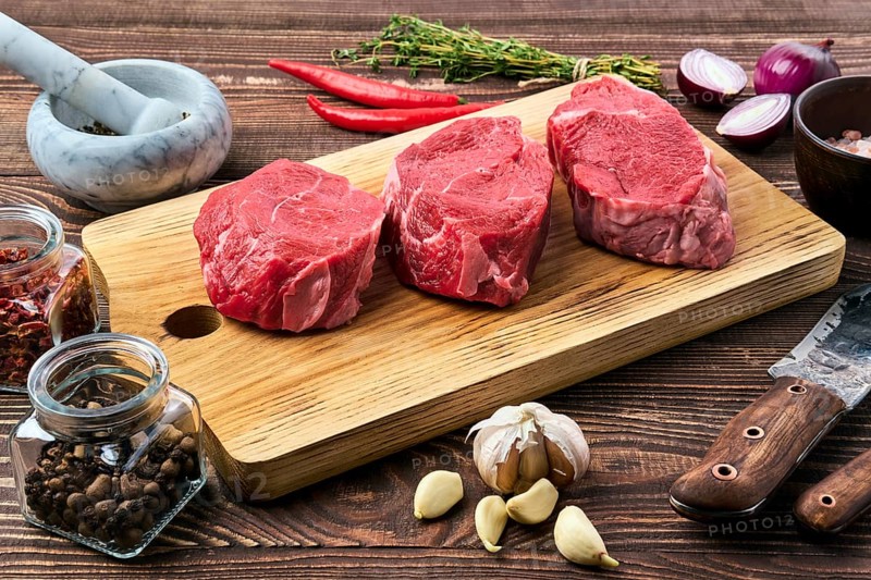 Marinated raw beef steak with spice on wooden table