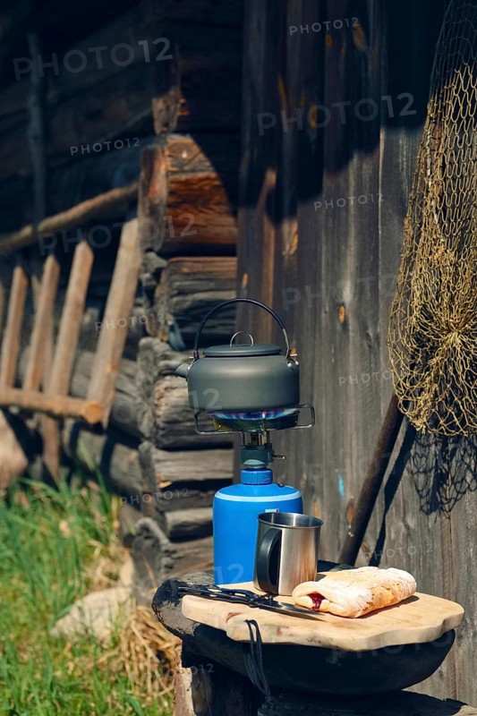 Boiling water in hiking kettle. Outdoor cooking equipment