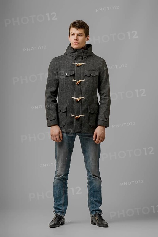 Full length portrait of handsome man in warm woolen coat posing in studio