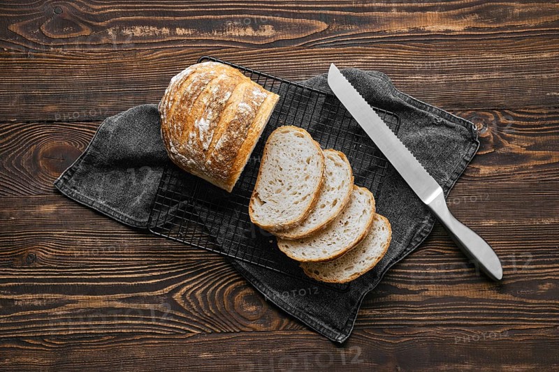 Overhead view of artisan whole grain wheat bread cut on slices on wooden table