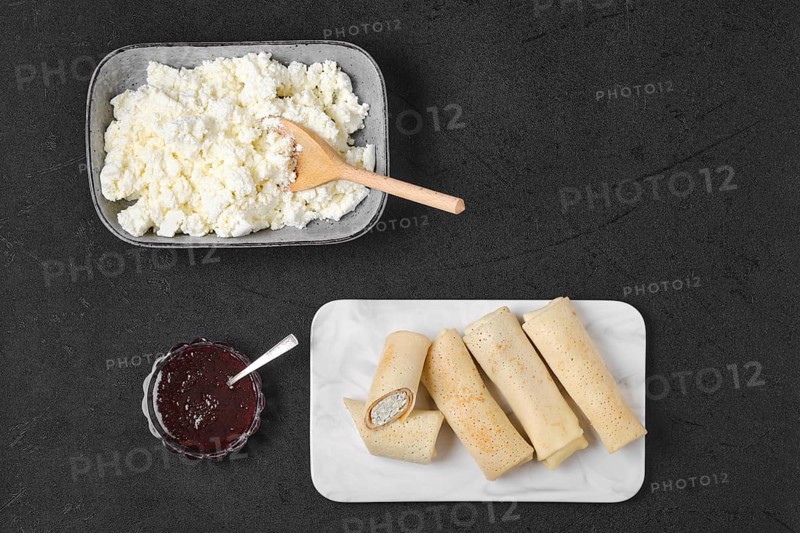 Overhead view of homemade pancakes stuffed with cottage cheese on marble serving plate