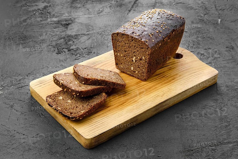 Top view of loaf of brown sourdough bread with sunflower seeds and sesame