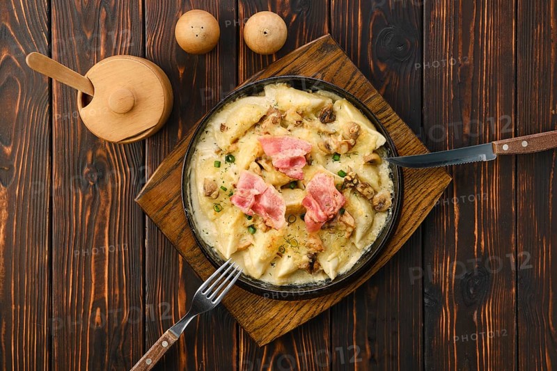 Top view of pan with fried meat dumplings with bacon and mushroom sauce