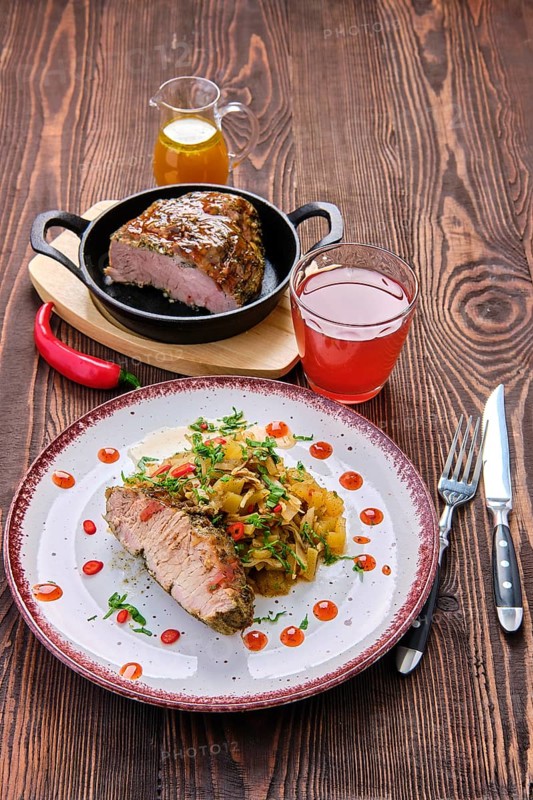 Oven-baked meat with braised cabbage and zucchini and hot spicy sauce