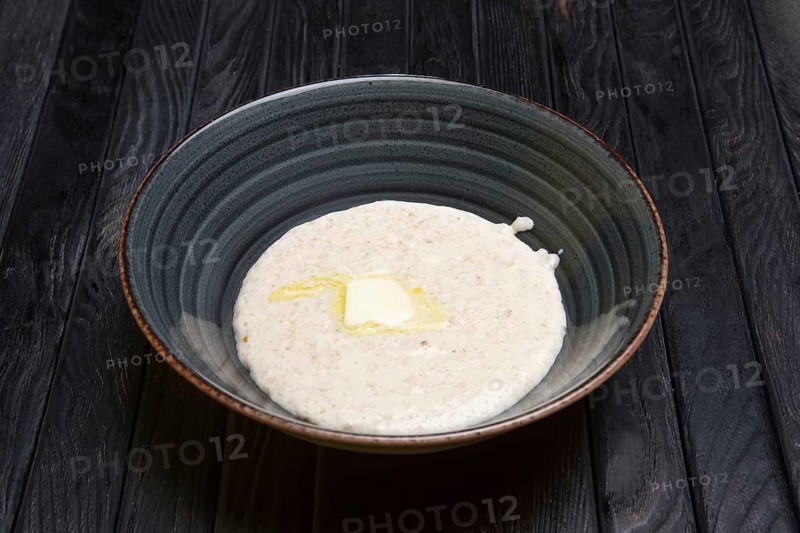 Plate with oatmeal and piece of butter